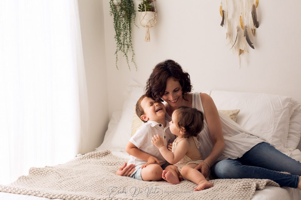 mamma e figli mesi giocano sul letto