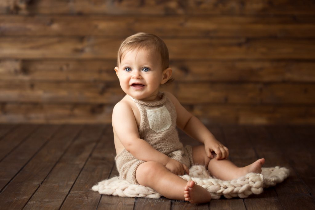 bambino 10 mesi studio fotografico ritratto fondo legno