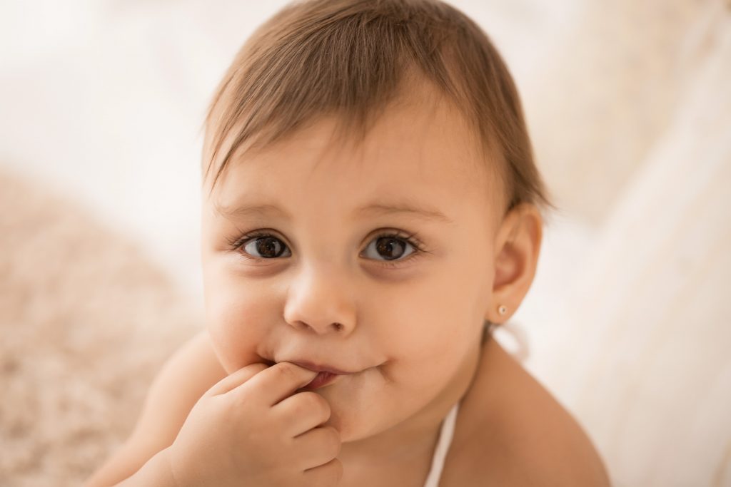 bambina di 12 mesi gioca sul letto