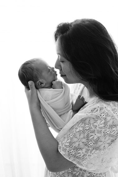 Ritratto newborn in studio a Milano, neonato addormentato avvolto in una coperta chiara