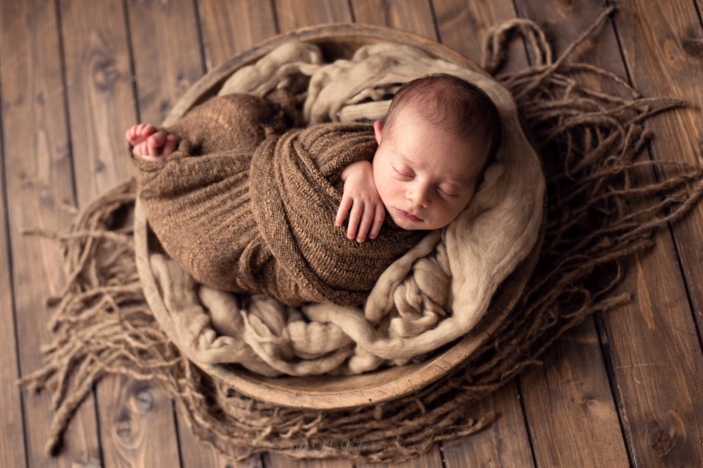 neonato in ciotola di legno
