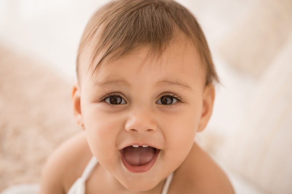 bambina di 12 mesi gioca sul letto