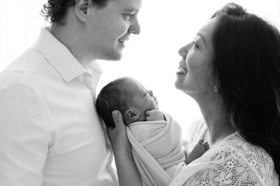 Foto professionale di neonato con mamma e papà, ritratti intimi in studio