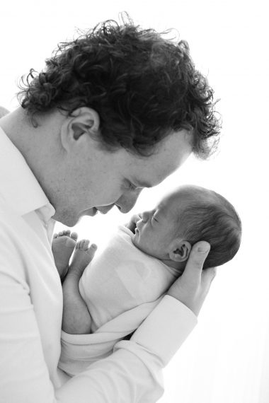 Foto professionale di neonato con papà, ritratti intimi in studio