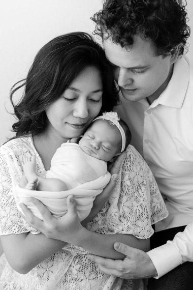 Foto professionale di neonato con mamma e papà, ritratti intimi in studio