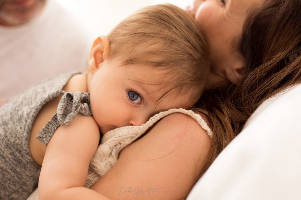 bambino 10 mesi in braccio ai genitori ride