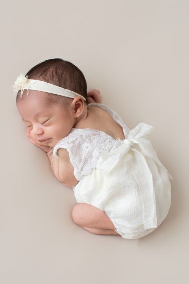 Ritratto newborn in studio a Milano, neonato addormentato avvolto in una coperta chiara